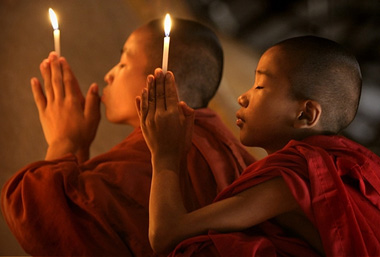 Young Buddhist Monks with candles